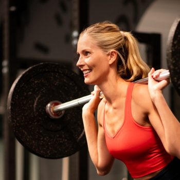 Kuntosalilla nainen kyykkää